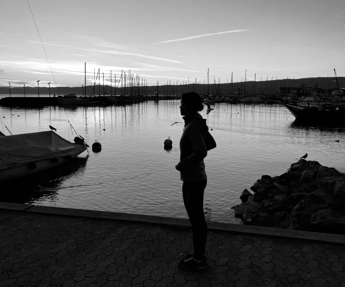 Silhouette de Marine Buffon au bord du lac, face aux voiliers